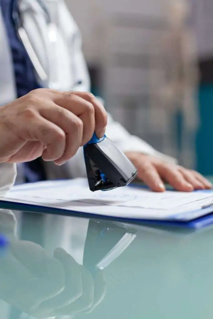 doctor-holding-medical-stamp-put-prescription-paper-health-care-exam-hand-physician-putting-seal-checkup-report-giving-medicine-patient-consultation-close-up